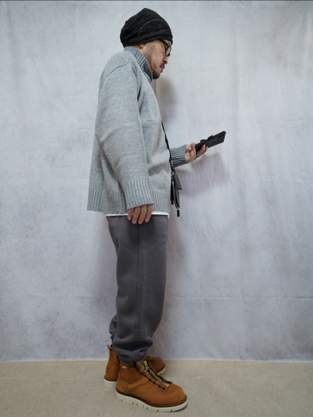 ブラウン系のブーツ、グレー系のスウェットパンツ、グレー系のニット/セーターを着用したメンズの冬コーディネートの3枚目の写真