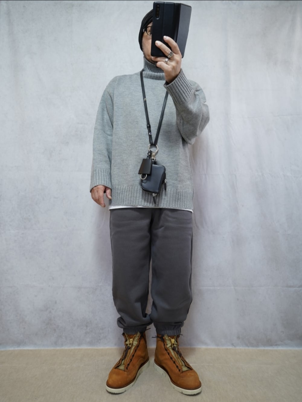 ブラウン系のブーツ、グレー系のスウェットパンツ、グレー系のニット/セーターを着用したメンズの冬コーディネートの4枚目の写真