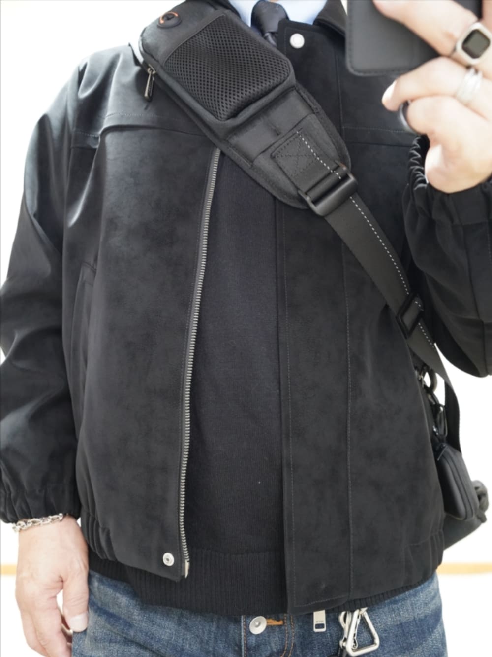 ブラック系のドレスシューズ、ブルー系のデニムパンツ、ブラック系のニット/セーターを着用したメンズの冬コーディネートの4枚目の写真