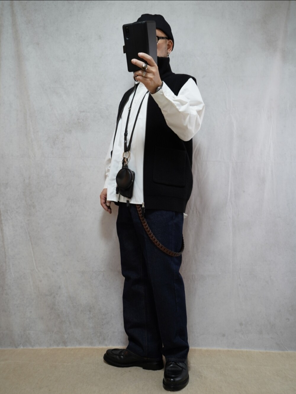 ブラック系のシューズ、ブルー系のデニムパンツ、ブラック系のショルダーバッグを着用したメンズの冬コーディネートの2枚目の写真