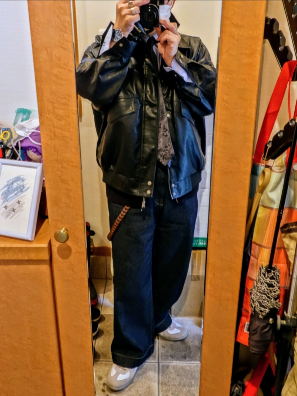 ホワイト系のスニーカー、ブルー系のデニムパンツ、ブラック系のネクタイを着用したメンズの春コーディネートの2枚目の写真