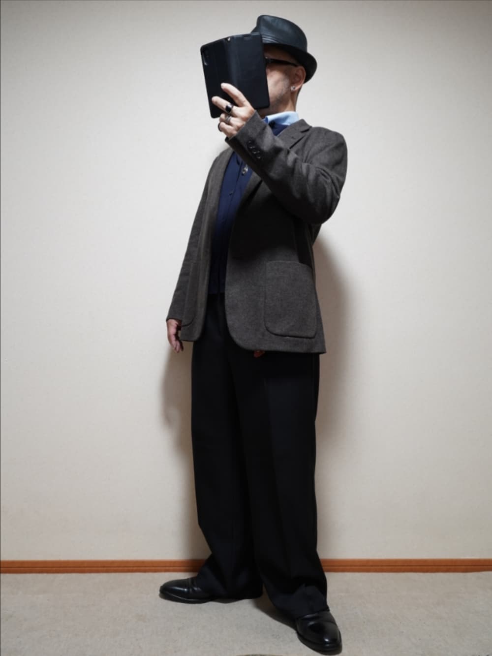 ブラック系のドレスシューズ、ブラック系のパンツ、ブルー系のカーディガン/ボレロを着用したメンズの冬コーディネートの2枚目の写真