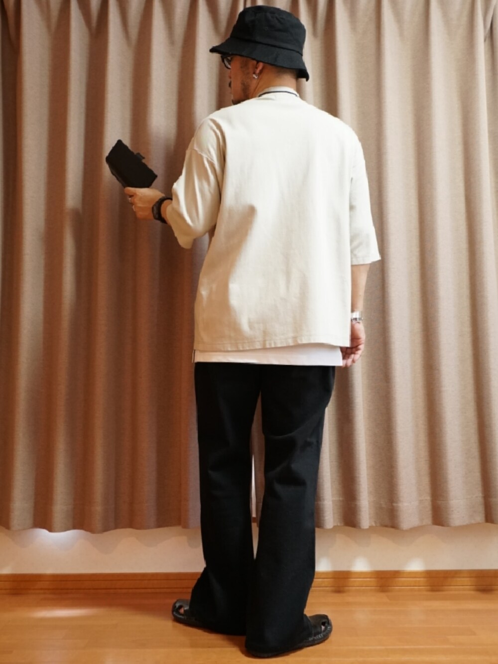 ブラック系のサンダル、グレー系のデニムパンツ、ホワイト系のタンクトップを着用したメンズの夏コーディネートの3枚目の写真