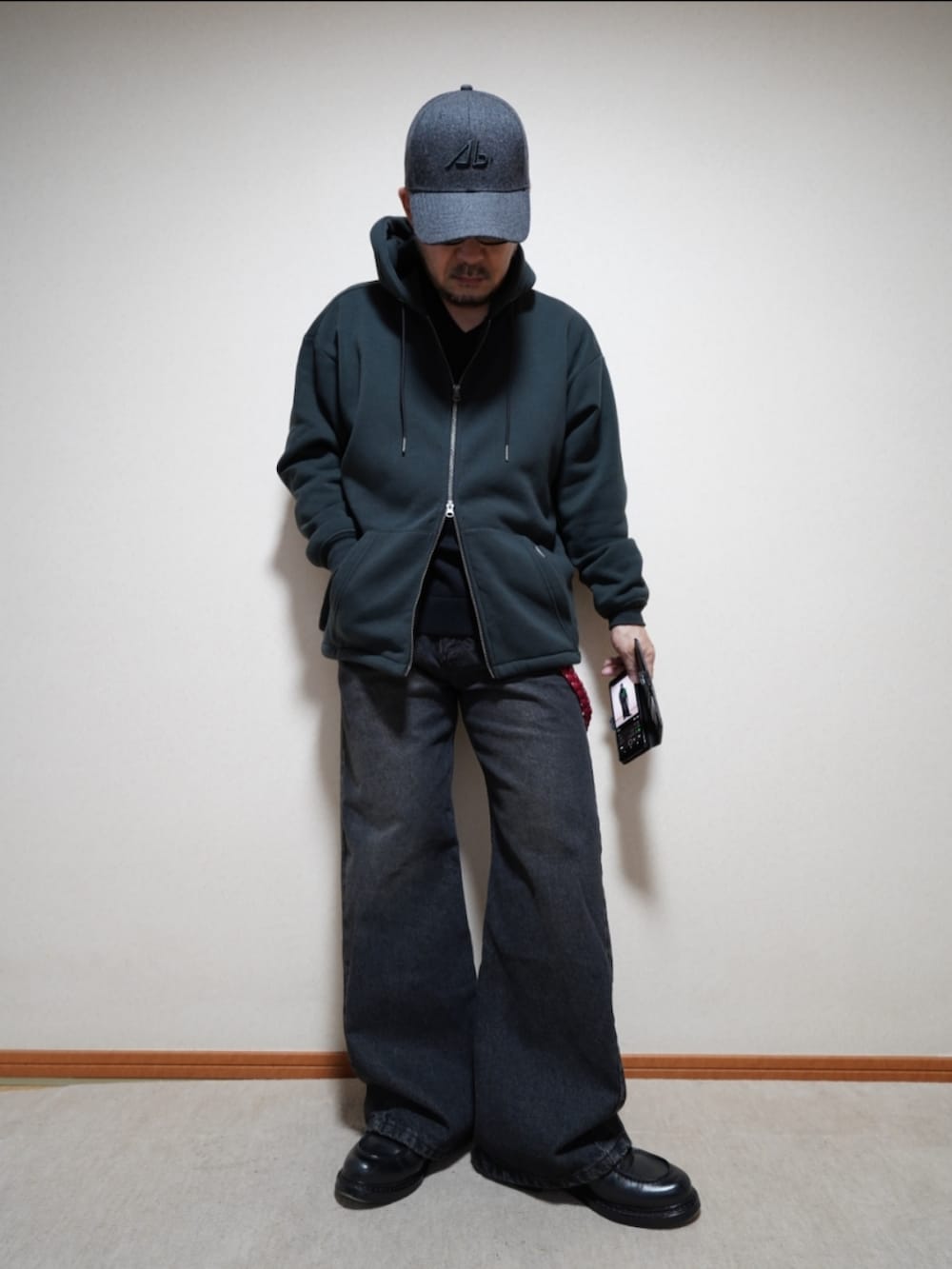 ブラック系のシューズ、ブラック系のデニムパンツ、ブラック系のパーカーを着用したメンズの春コーディネートの3枚目の写真