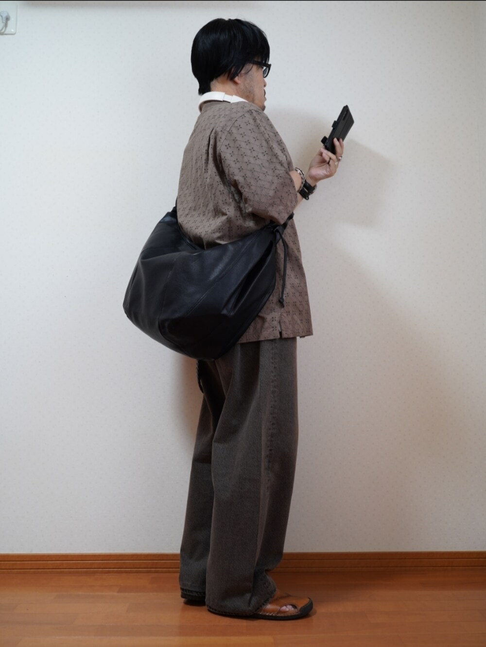 ブラック系のサンダル、ブラウン系のデニムパンツ、ブラウン系のシャツ/ブラウスを着用したメンズの夏コーディネートの5枚目の写真