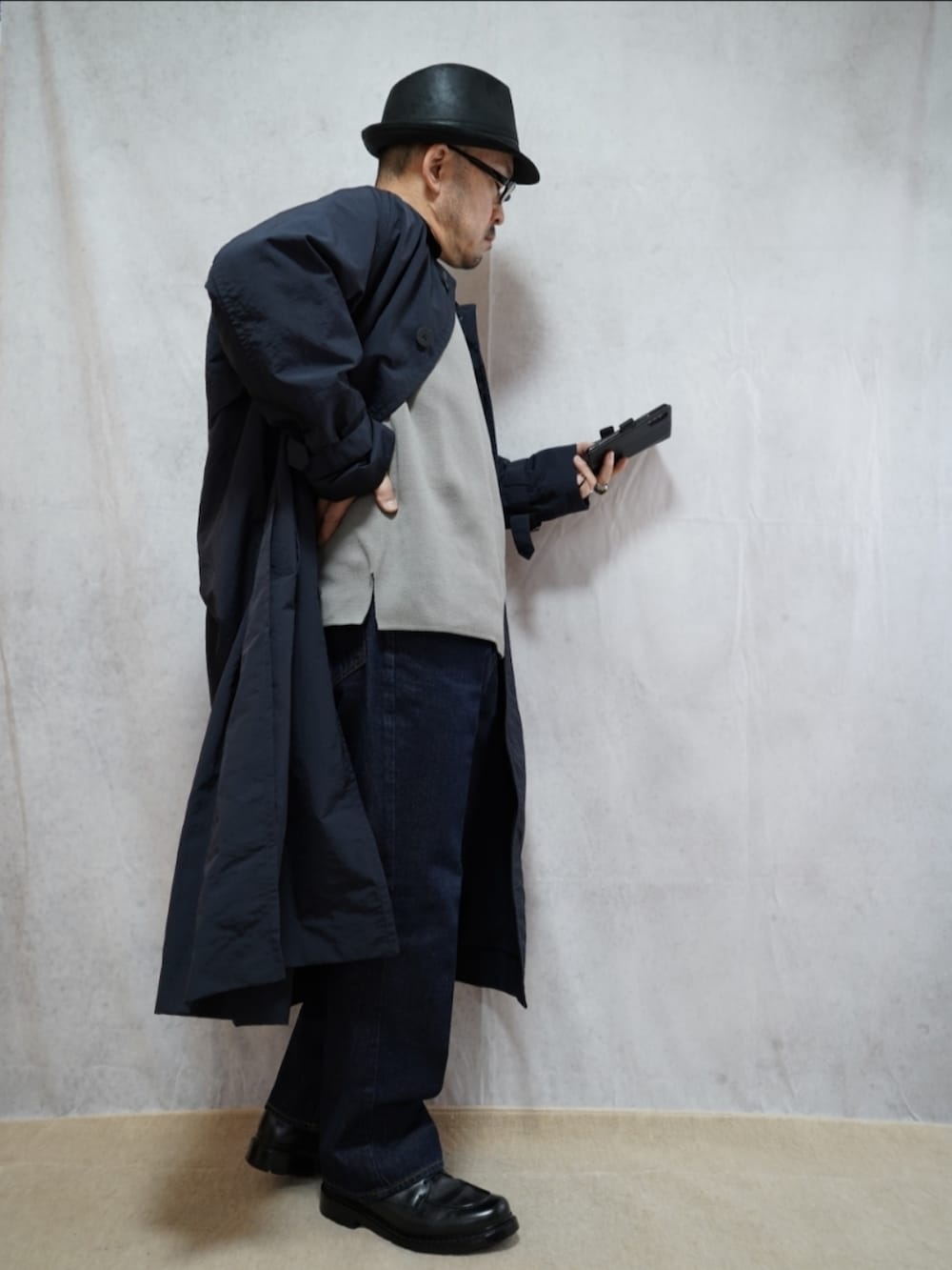 ブラック系のシューズ、ブルー系のデニムパンツ、グレー系のニット/セーターを着用したメンズの冬コーディネートの4枚目の写真
