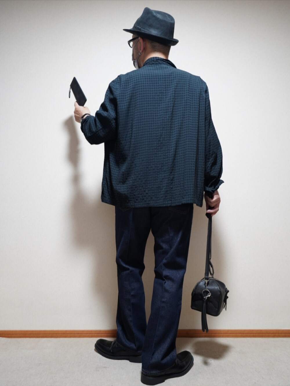 ブラック系のシューズ、ブルー系のデニムパンツ、ブラック系のショルダーバッグを着用したメンズの夏コーディネートの3枚目の写真