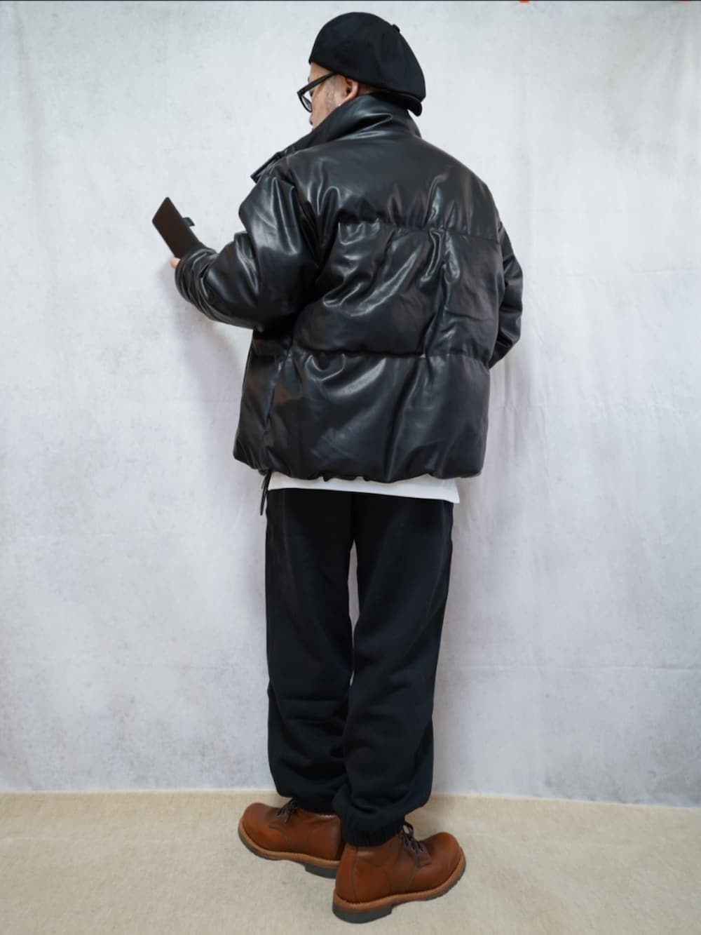 ブラウン系のブーツ、ブラック系のスウェットパンツ、ブラック系のダウンジャケット/コートを着用したメンズの冬コーディネートの3枚目の写真