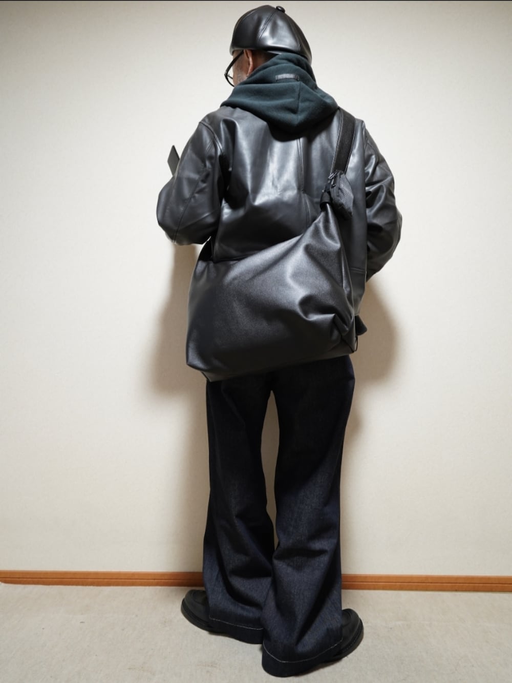 ブラック系のシューズ、ブルー系のデニムパンツ、ブラック系のパーカーを着用したメンズの冬コーディネートの4枚目の写真