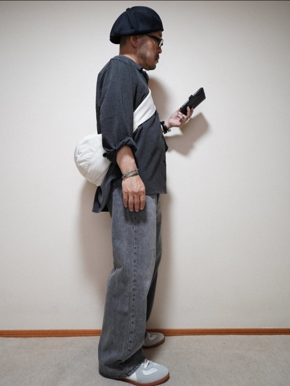 ホワイト系のスニーカー、グレー系のデニムパンツ、グレー系のシャツ/ブラウスを着用したメンズの秋コーディネートの5枚目の写真