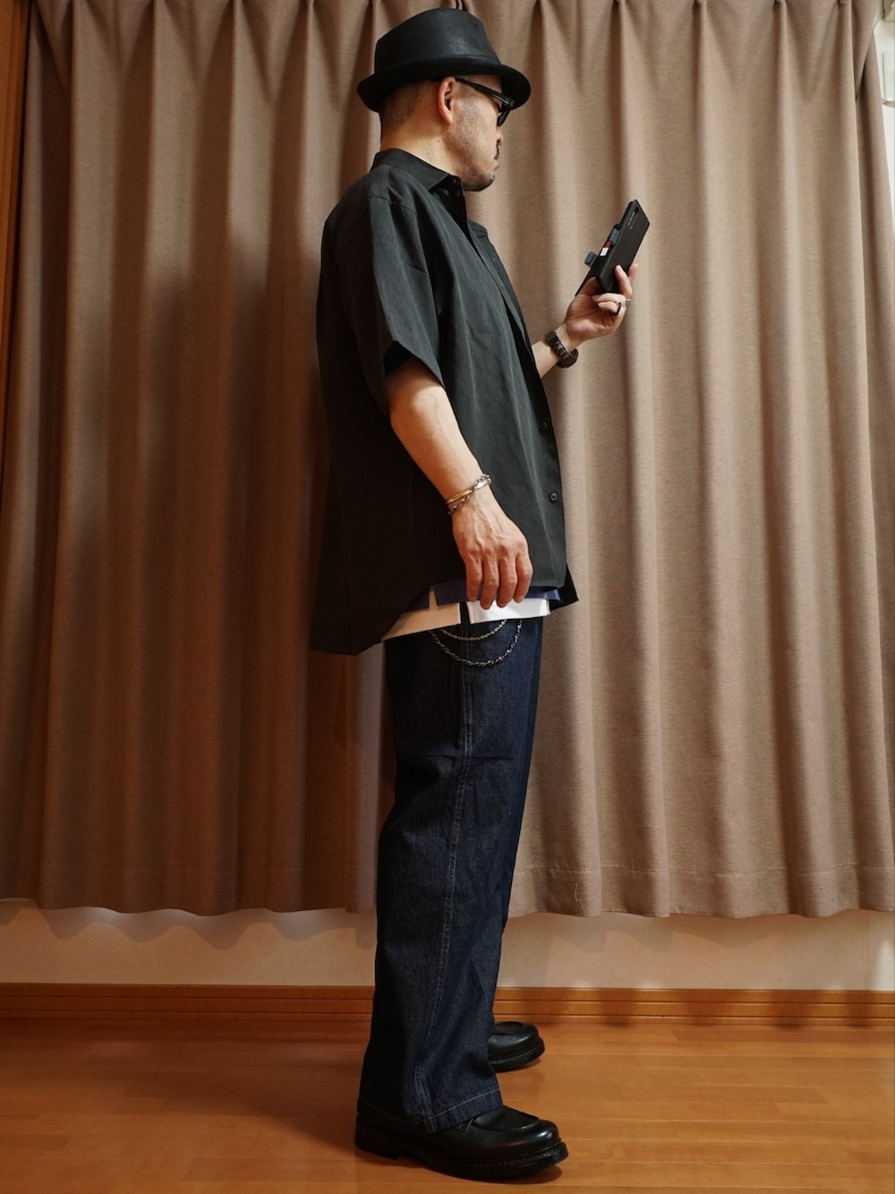 ブラック系のシューズ、ブルー系のデニムパンツ、ホワイト系のタンクトップを着用したメンズの夏コーディネートの4枚目の写真