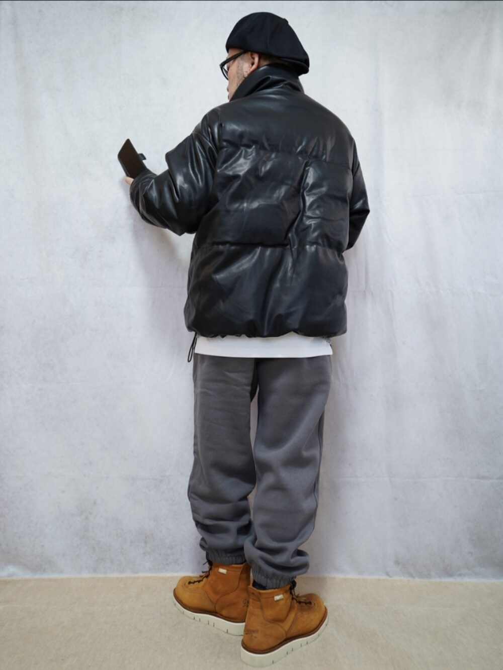 ブラウン系のブーツ、グレー系のスウェットパンツ、グレー系のニット/セーターを着用したメンズの冬コーディネートの2枚目の写真