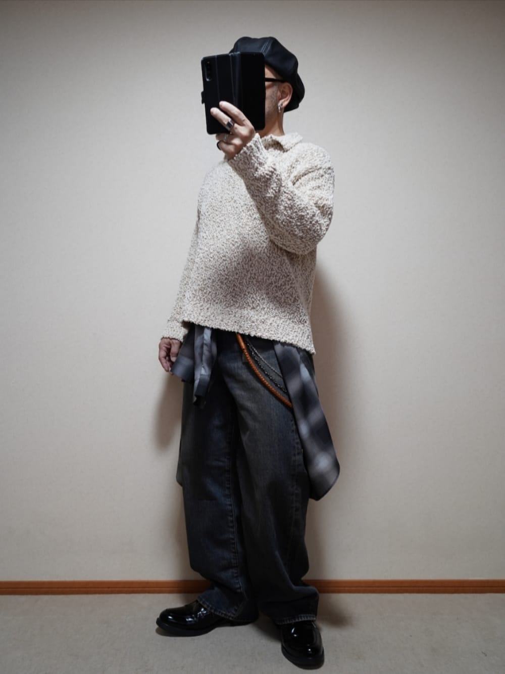ブラック系のシューズ、ブルー系のデニムパンツ、ホワイト系のニット/セーターを着用したメンズの春コーディネートの4枚目の写真