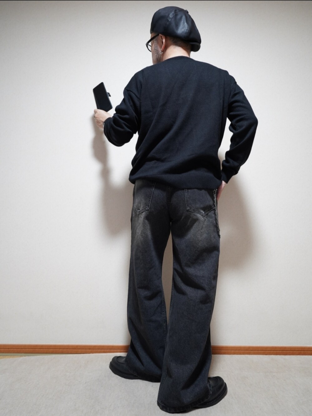 ブラック系のシューズ、ブラック系のデニムパンツ、ブラック系のニット/セーターを着用したメンズの春コーディネートの3枚目の写真