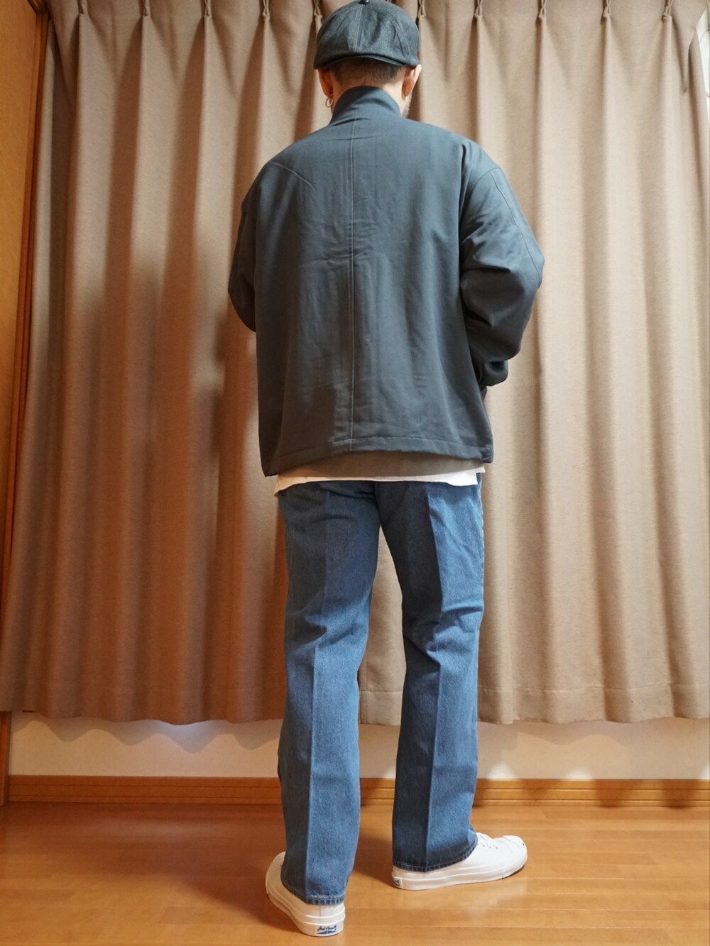 ホワイト系のスニーカー、ブルー系のデニムパンツ、グレー系のニット/セーターを着用したメンズの夏コーディネートの4枚目の写真
