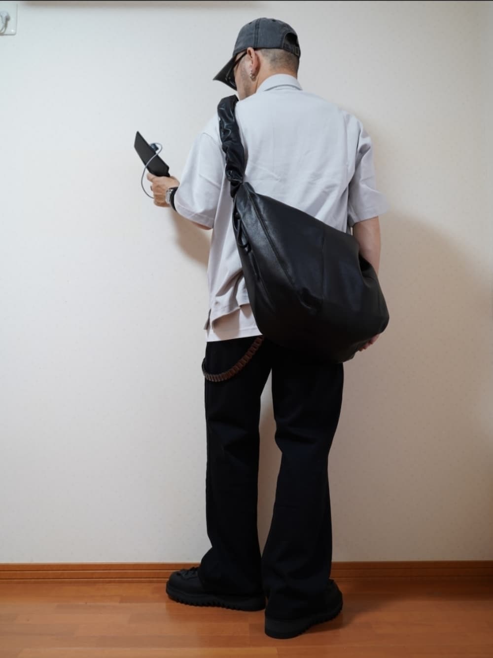 ブラック系のシューズ、グレー系のデニムパンツ、ブラック系のショルダーバッグを着用したメンズの夏コーディネートの2枚目の写真