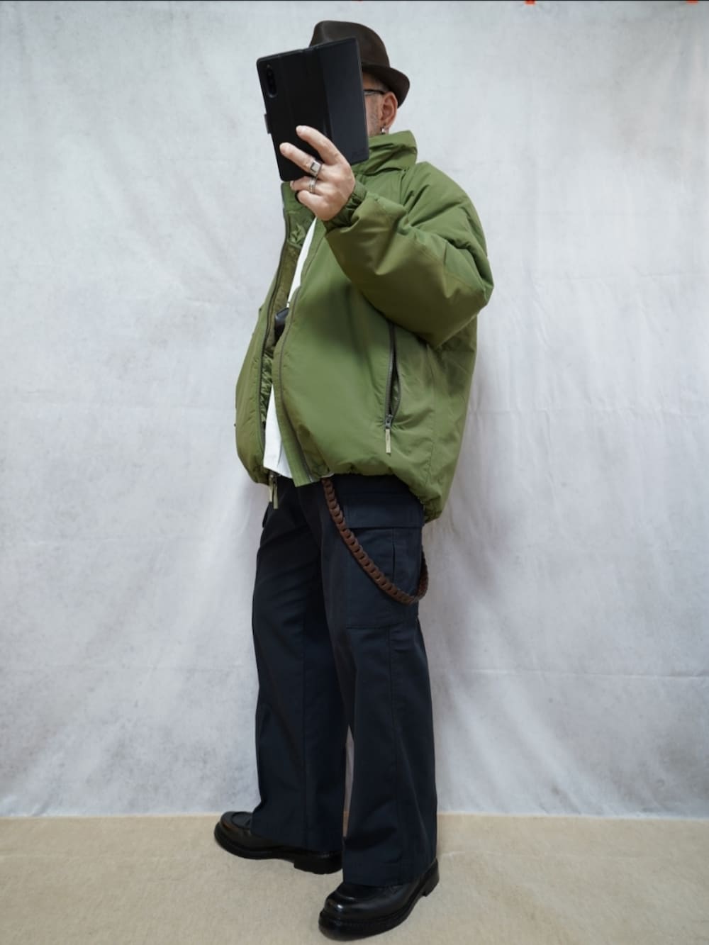 ブラック系のシューズ、グリーン系のダウンジャケット/コート、ホワイト系のシャツ/ブラウスを着用したメンズの冬コーディネートの2枚目の写真