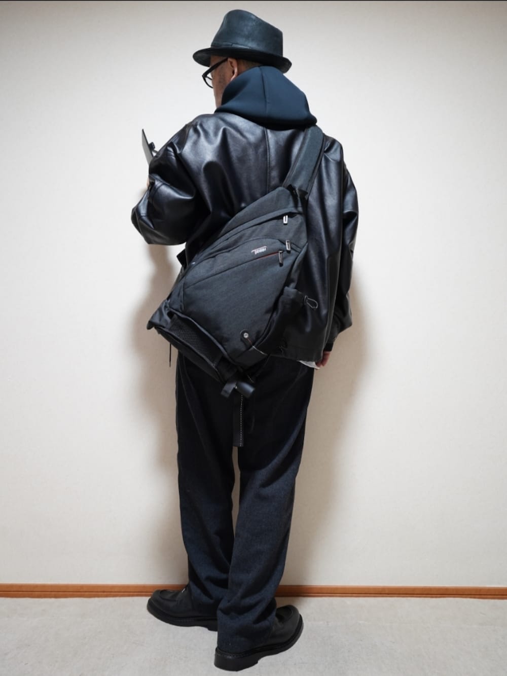 ブラック系のシューズ、グレー系のパンツ、ブラック系のパーカーを着用したメンズの秋コーディネートの3枚目の写真