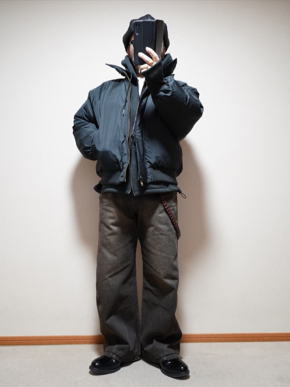 ブラック系のシューズ、ブラック系のデニムパンツ、ブラック系のパーカーを着用したメンズの春コーディネートの2枚目の写真