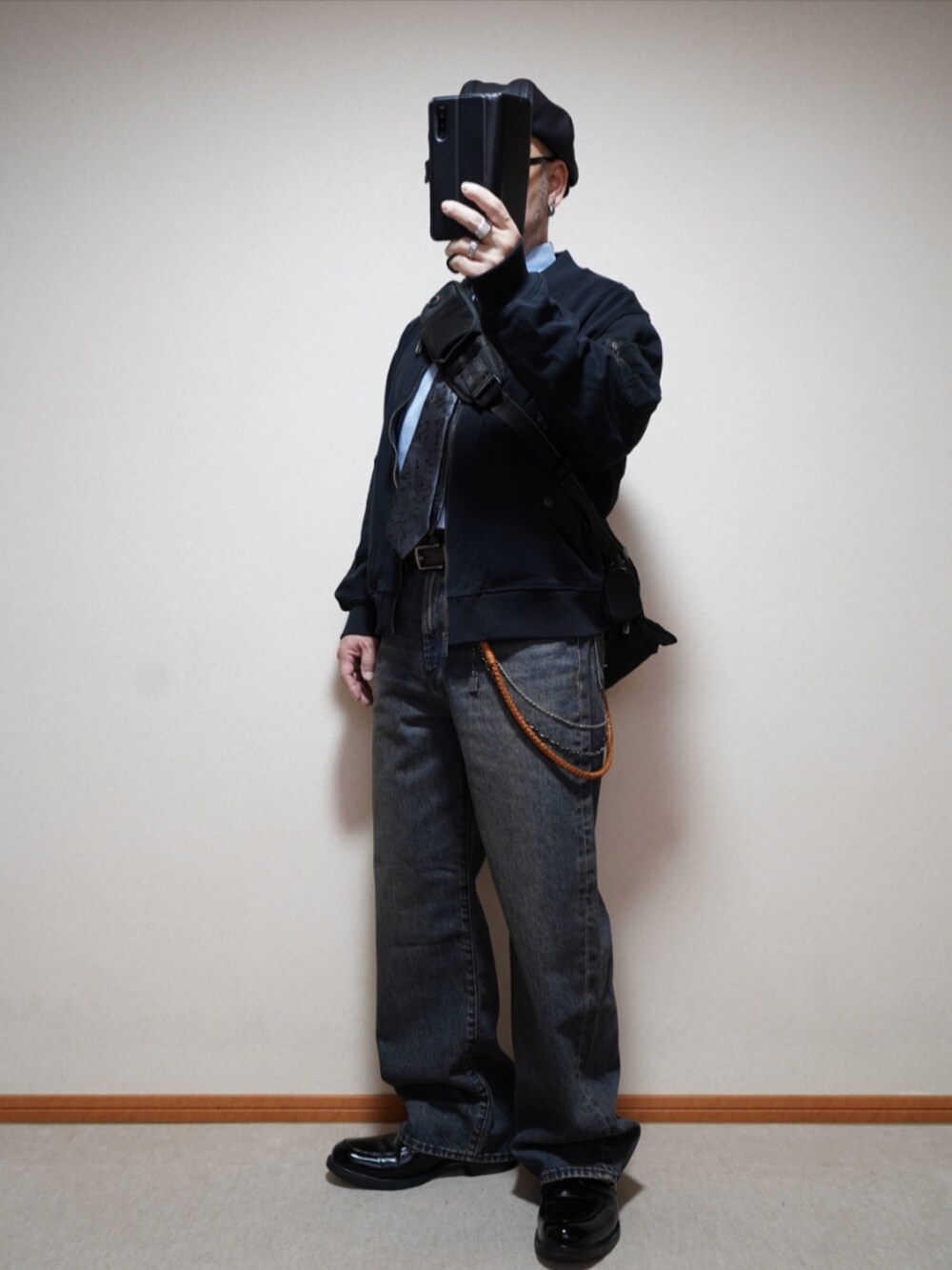 ブラック系のシューズ、ブルー系のデニムパンツ、ブラック系のMA-1を着用したメンズの春コーディネートの2枚目の写真