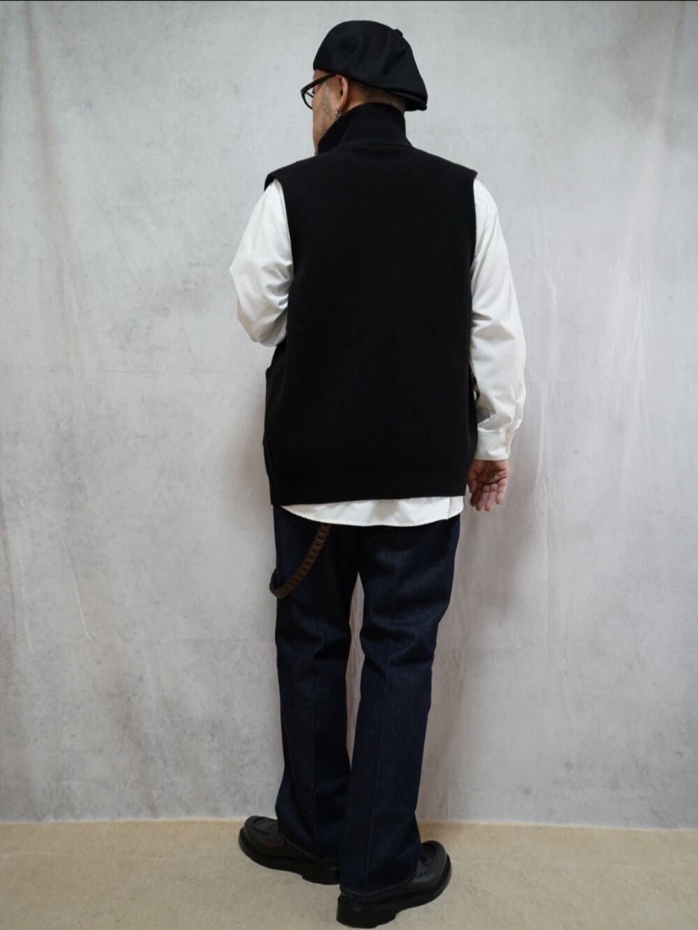 ブラック系のシューズ、ブルー系のデニムパンツ、ブラック系のショルダーバッグを着用したメンズの冬コーディネートの3枚目の写真