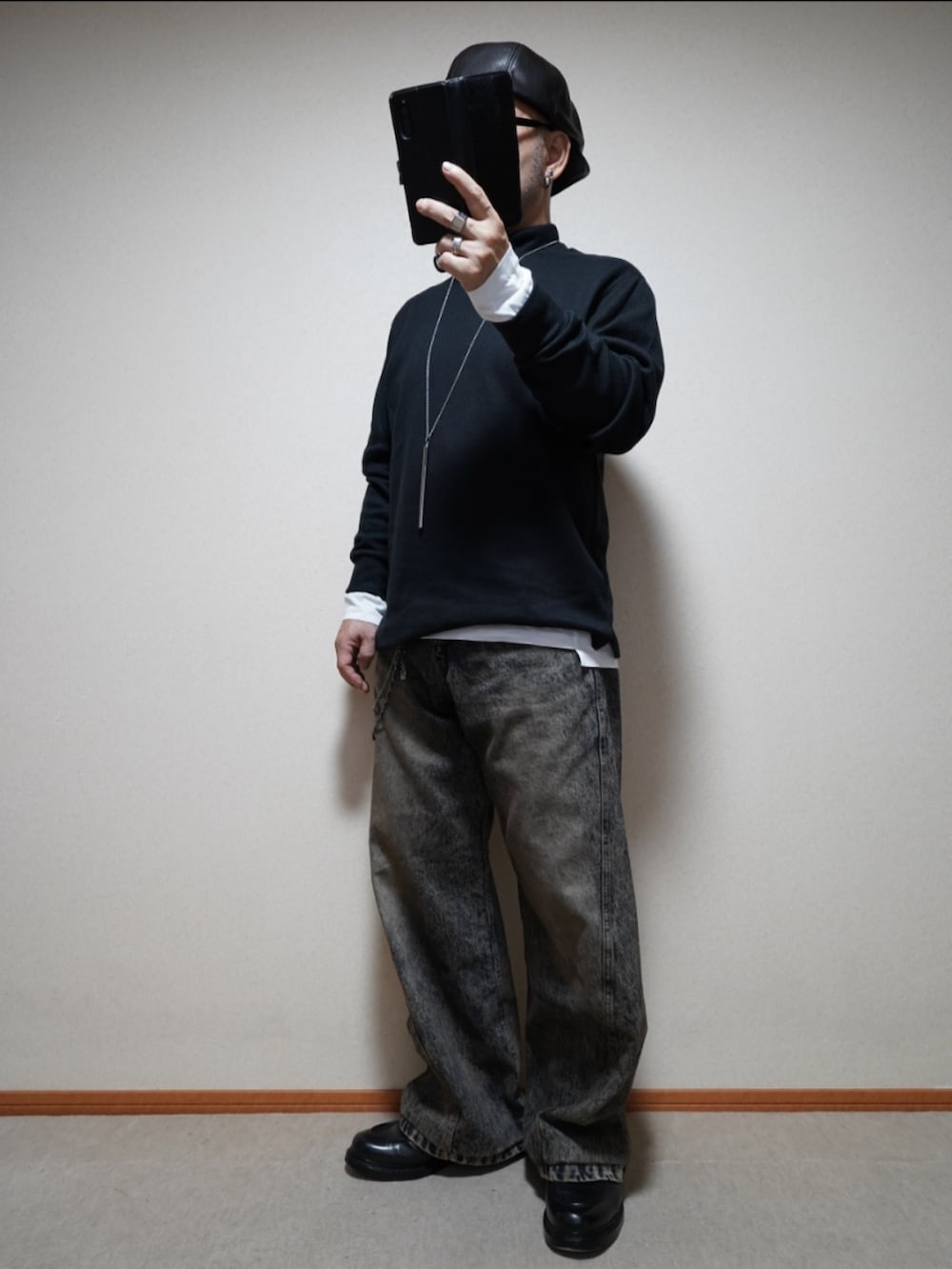 ブラック系のシューズ、ブルー系のデニムパンツ、ブラック系のトップスを着用したメンズの春コーディネートの2枚目の写真