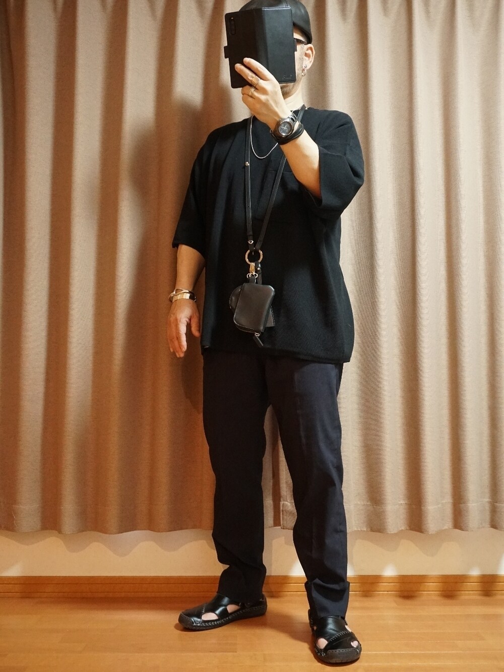グレー系のパンツ、ブラック系のショルダーバッグ、ブラック系のニット/セーターを着用したメンズの夏コーディネートの3枚目の写真