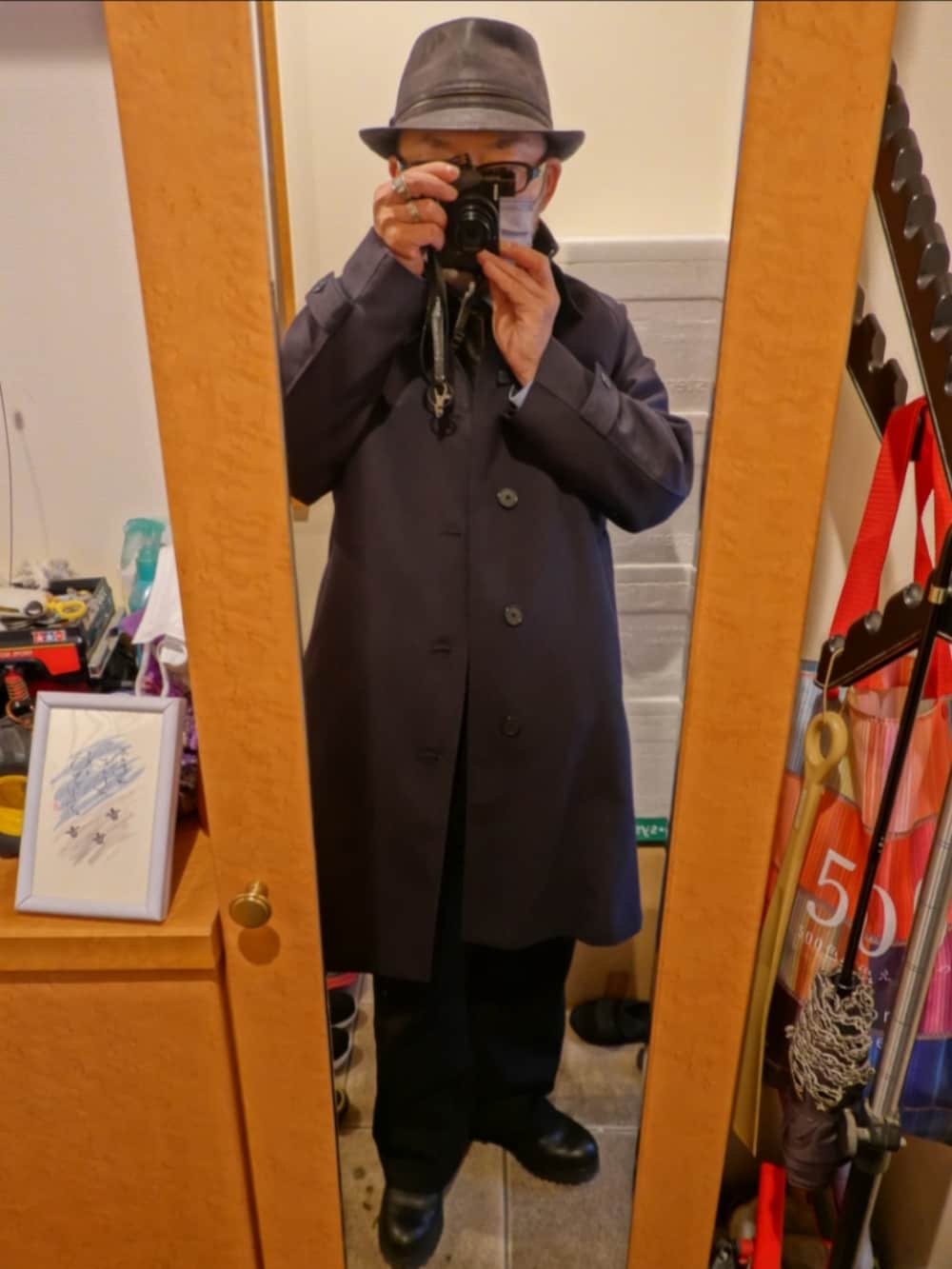 グレー系のデニムパンツ、グレー系のブルゾン、ブルー系のステンカラーコートを着用したメンズの春コーディネートの5枚目の写真