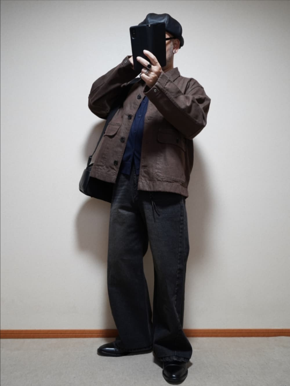 ブラック系のドレスシューズ、ブラック系のデニムパンツ、ブルー系のカーディガン/ボレロを着用したメンズの秋コーディネートの2枚目の写真