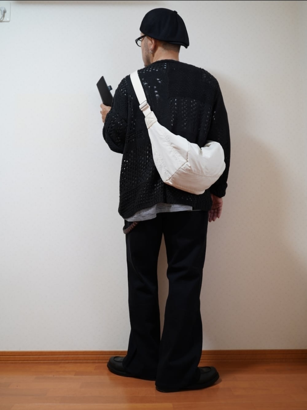 ブラック系のシューズ、グレー系のデニムパンツ、ブラック系のニット/セーターを着用したメンズの夏コーディネートの2枚目の写真