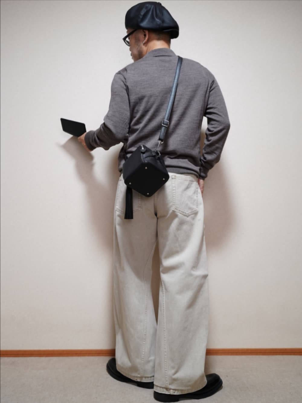 ブラック系のシューズ、ベージュ系のデニムパンツ、ブラック系のショルダーバッグを着用したメンズの秋コーディネートの4枚目の写真