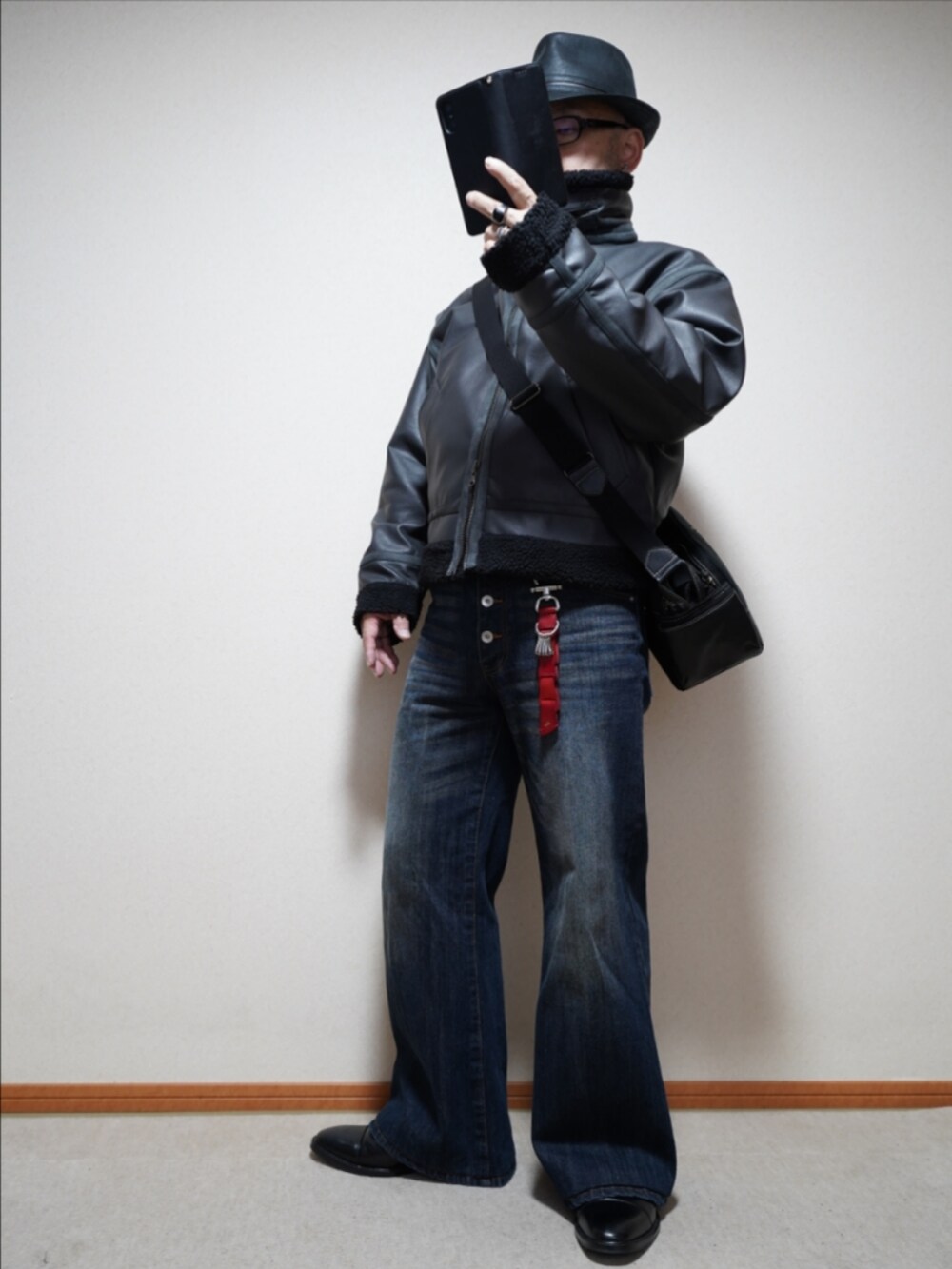 ブラック系のドレスシューズ、ブルー系のデニムパンツ、グレー系のブルゾンを着用したメンズの冬コーディネートの2枚目の写真