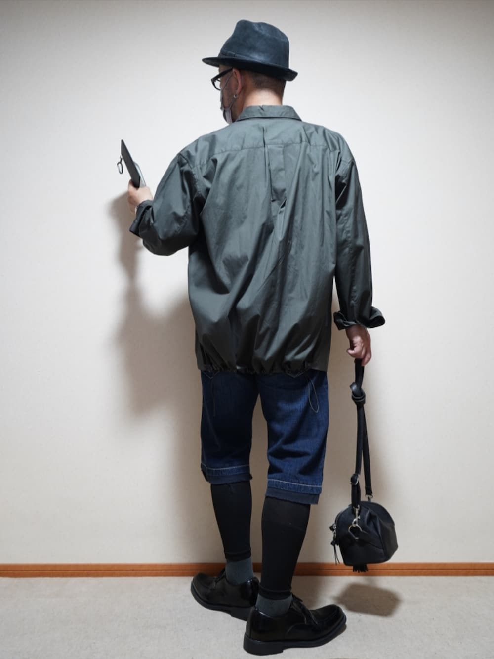 ブラック系のシューズ、ブルー系のパンツ、ブラック系のショルダーバッグを着用したメンズの夏コーディネートの3枚目の写真