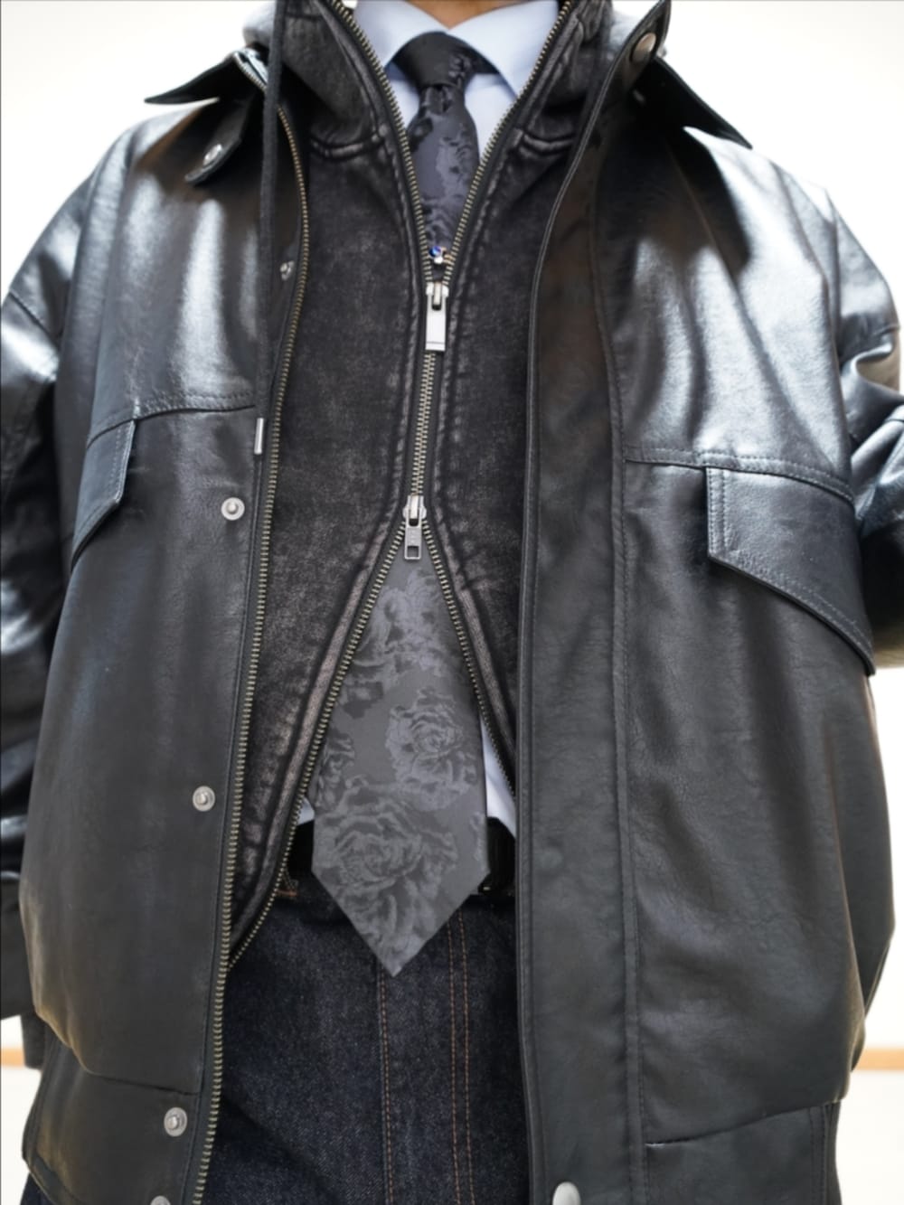 ブラック系のドレスシューズ、ブルー系のデニムパンツ、ブラック系のショルダーバッグを着用したメンズの冬コーディネートの3枚目の写真