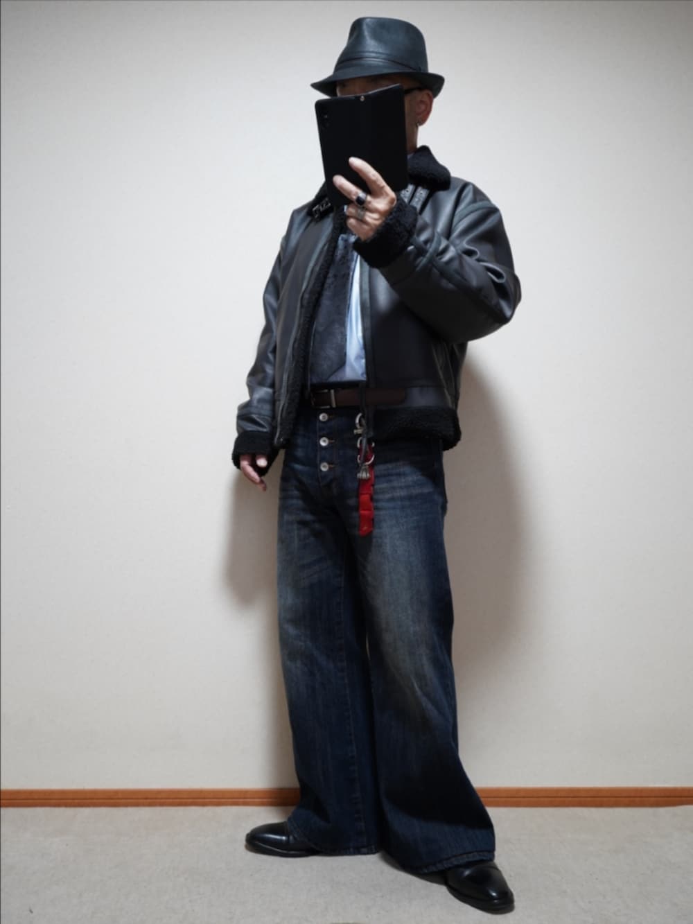 ブラック系のドレスシューズ、ブルー系のデニムパンツ、ブラック系のネクタイを着用したメンズの秋コーディネートの2枚目の写真