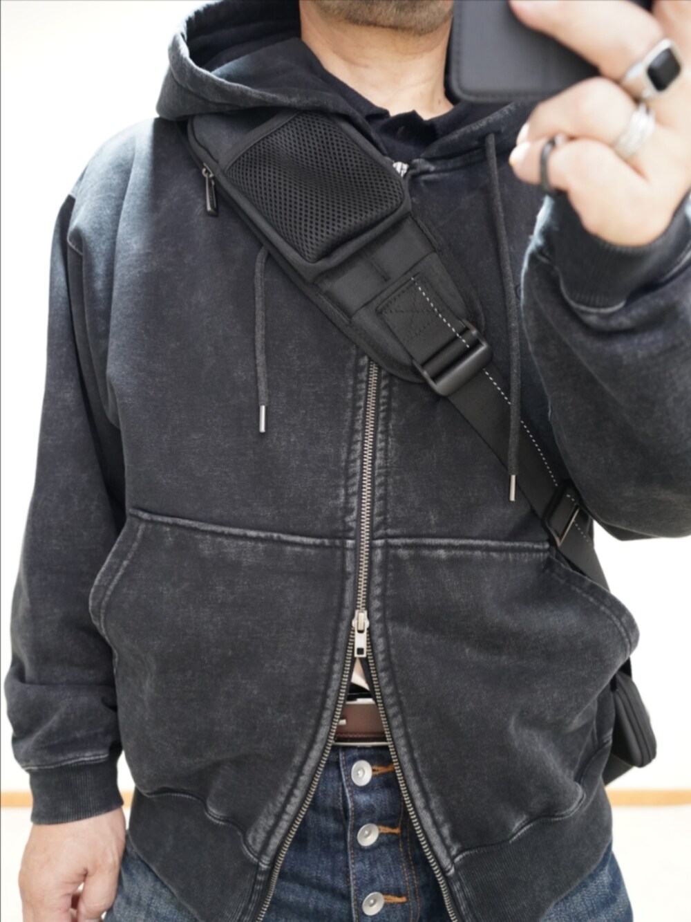 ブラック系のドレスシューズ、ブルー系のデニムパンツ、ブラック系のパーカーを着用したメンズの冬コーディネートの4枚目の写真