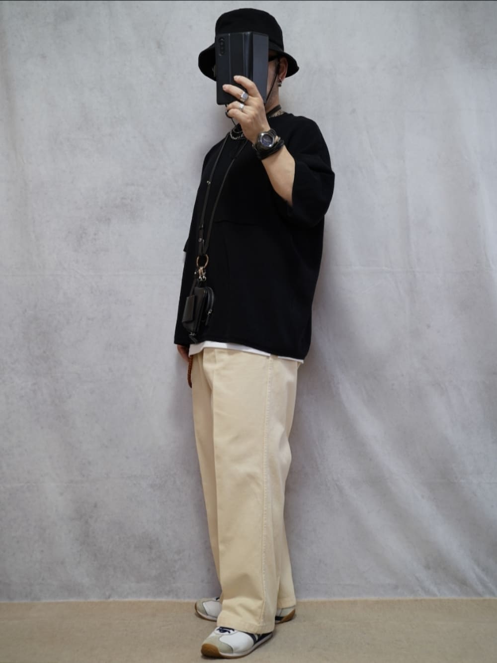 ホワイト系のスニーカー、ホワイト系のデニムパンツ、ブラック系のTシャツ/カットソーを着用したメンズの夏コーディネートの2枚目の写真