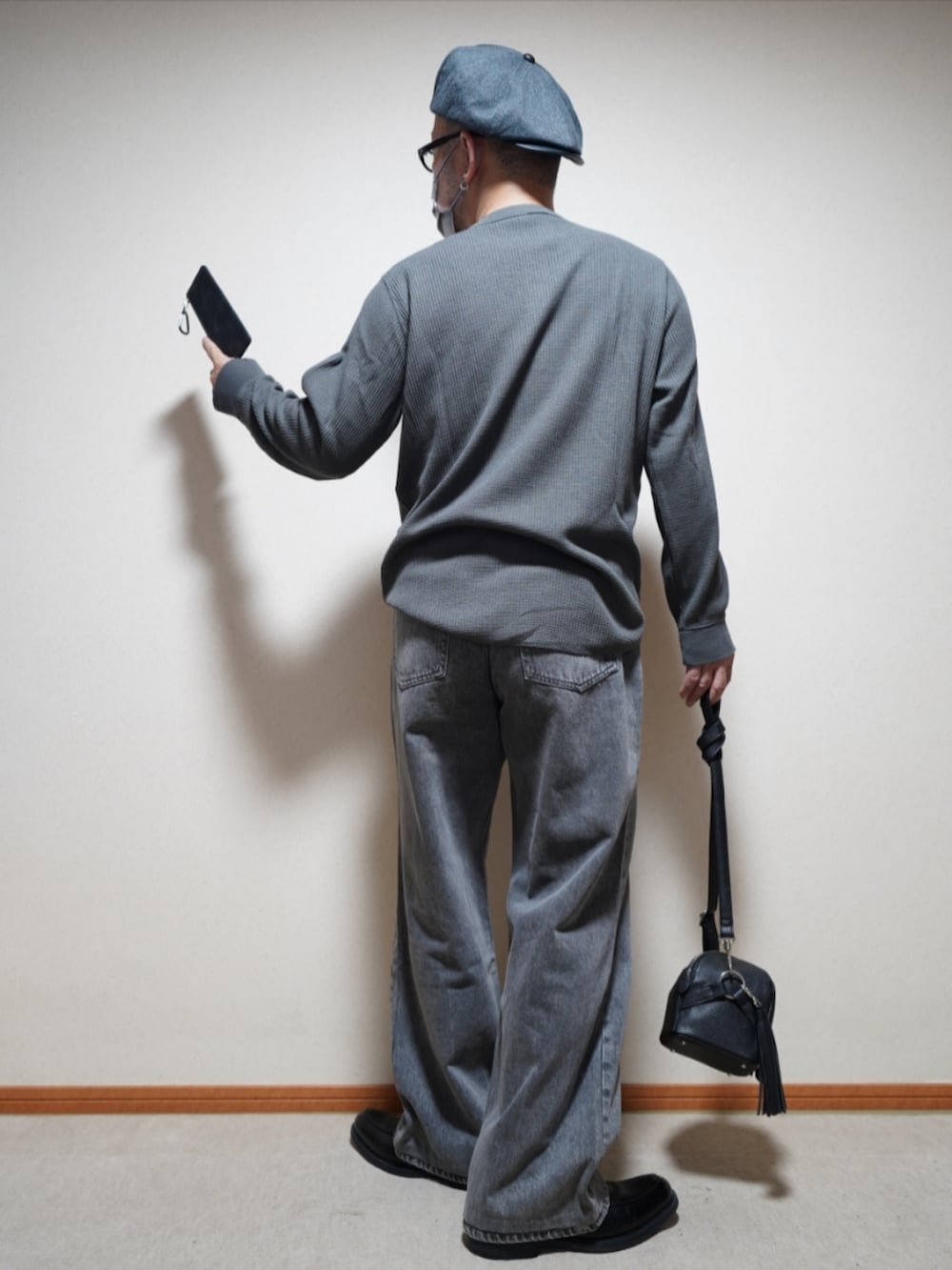 ブラック系のシューズ、グレー系のデニムパンツ、ブラック系のショルダーバッグを着用したメンズの夏コーディネートの3枚目の写真