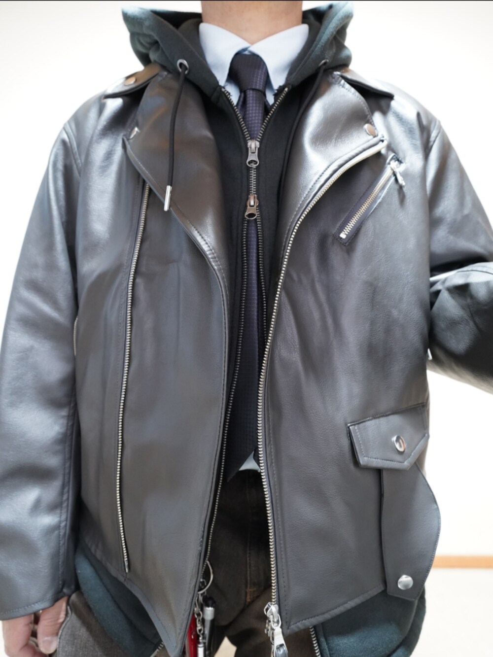 ブラック系のシューズ、ブラック系のパーカー、グレー系のライダースジャケットを着用したメンズの冬コーディネートの3枚目の写真