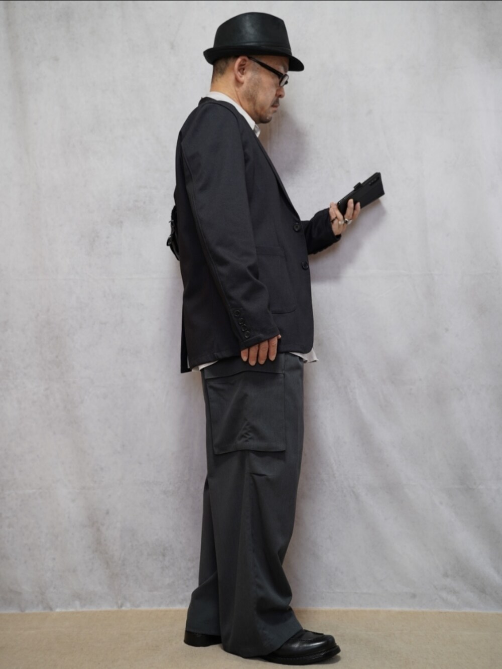 ブラック系のシューズ、グレー系のカーゴパンツ、ホワイト系のシャツ/ブラウスを着用したメンズの春コーディネートの4枚目の写真