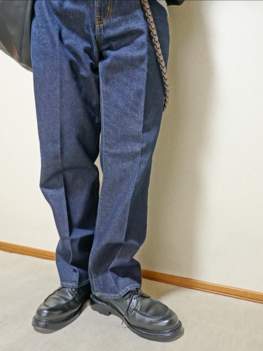 ブラック系のシューズ、ブルー系のデニムパンツ、ブラック系のTシャツ/カットソーを着用したメンズの夏コーディネートの4枚目の写真