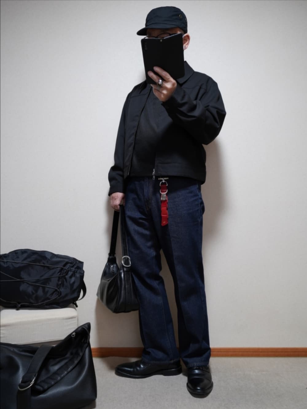 ブラック系のドレスシューズ、ブルー系のデニムパンツ、ブラック系のショルダーバッグを着用したメンズの春コーディネートの2枚目の写真