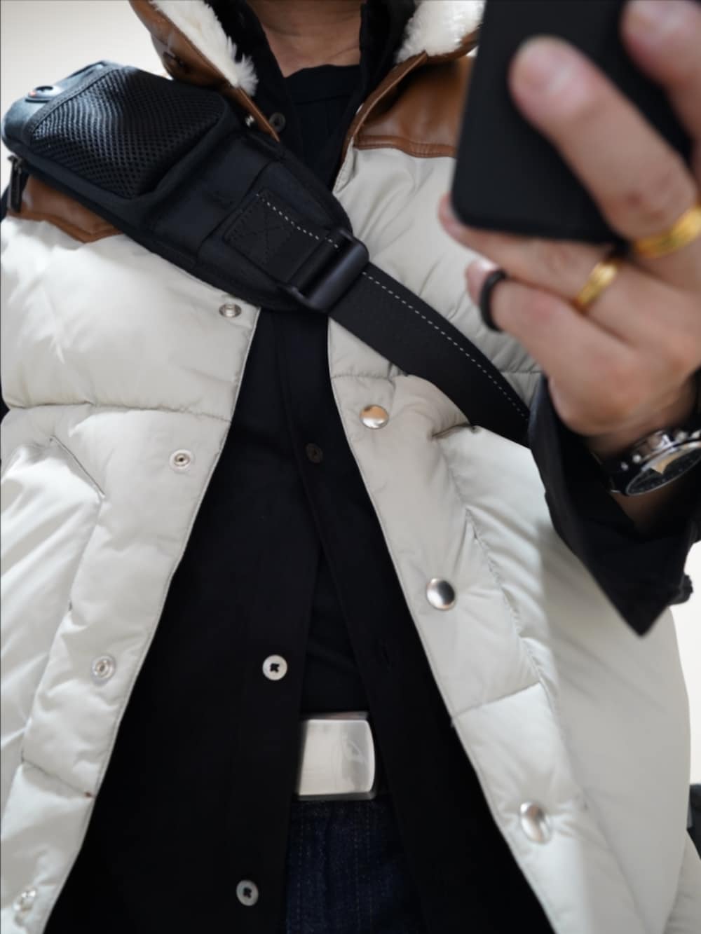 ブラック系のブーツ、ブルー系のデニムパンツ、その他のダウンベストを着用したメンズの秋コーディネートの4枚目の写真