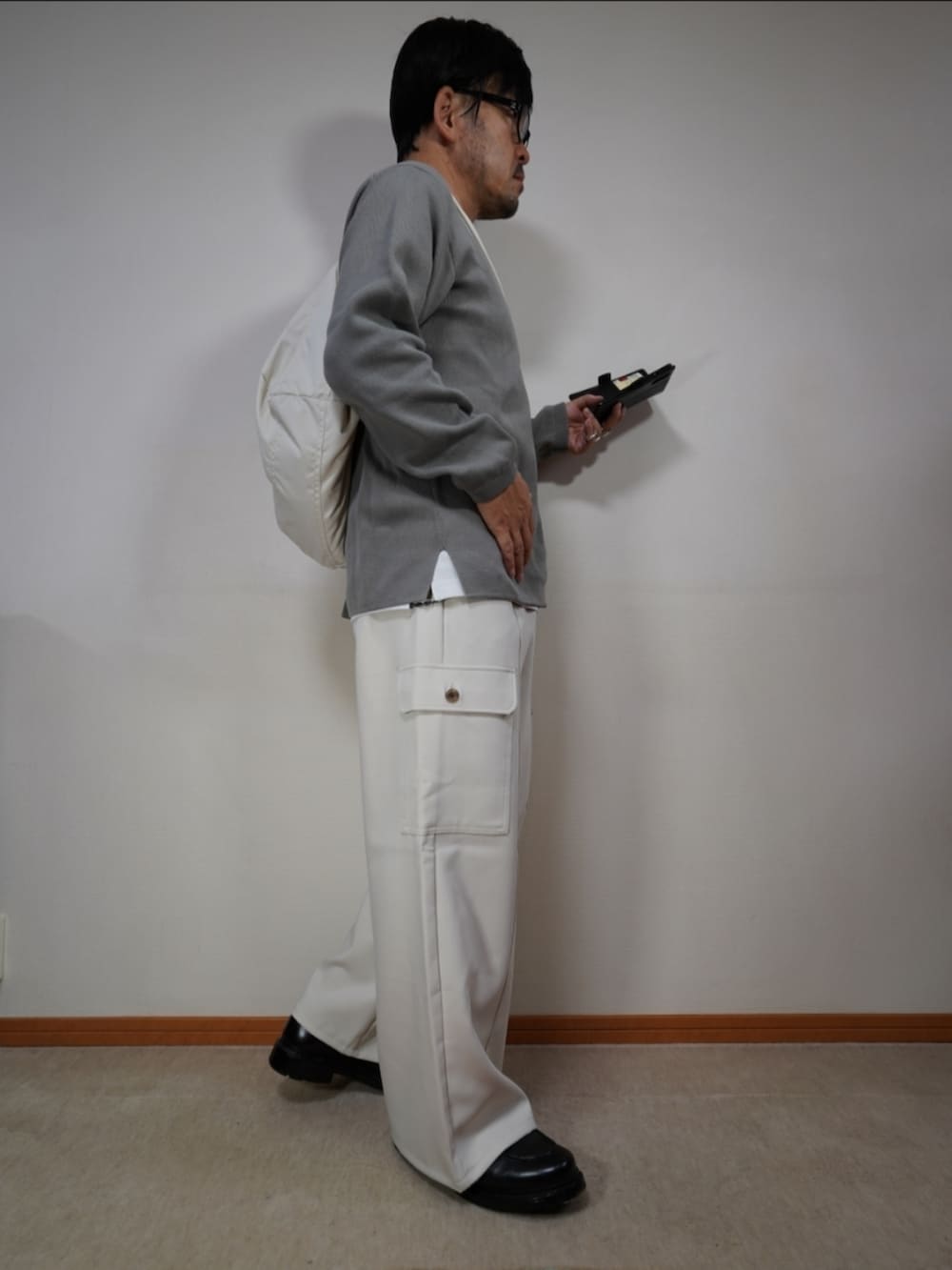 ブラック系のシューズ、ブラウン系のカーゴパンツ、グレー系のニット/セーターを着用したメンズの秋コーディネートの3枚目の写真