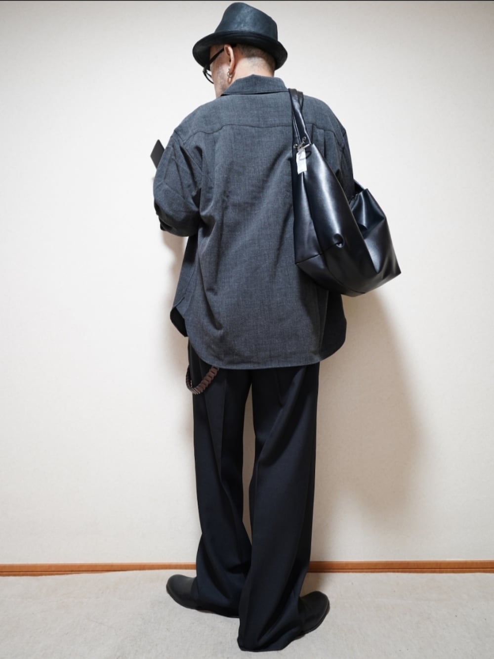 ブラック系のスリッポン、ブラック系のパンツ、ブラック系のショルダーバッグを着用したメンズの秋コーディネートの3枚目の写真