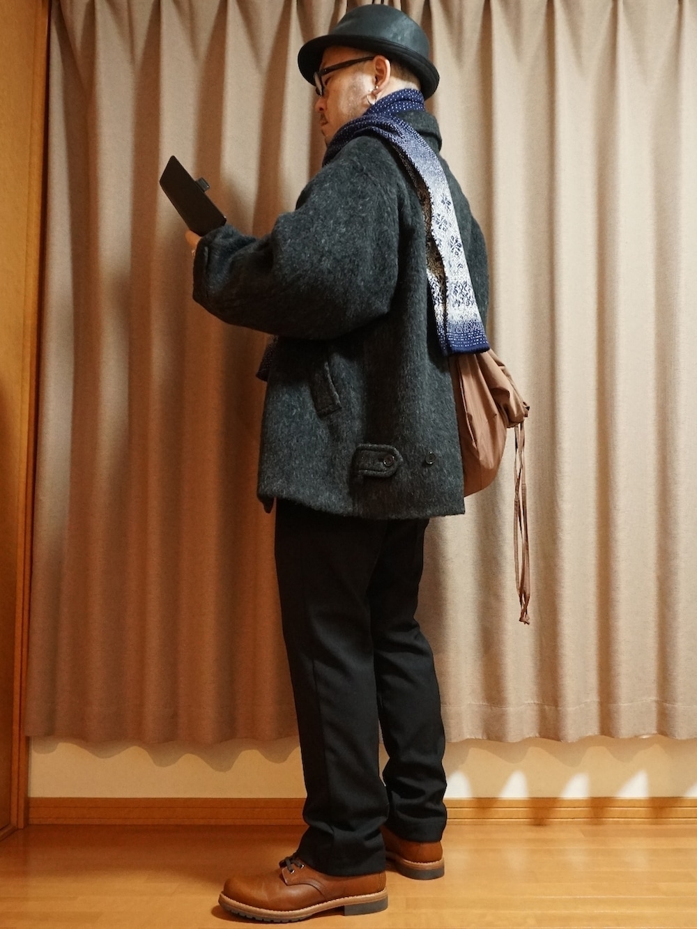 ブラウン系のブーツ、ブラック系のスラックス、ブラック系のトップスを着用したメンズの秋コーディネートの2枚目の写真