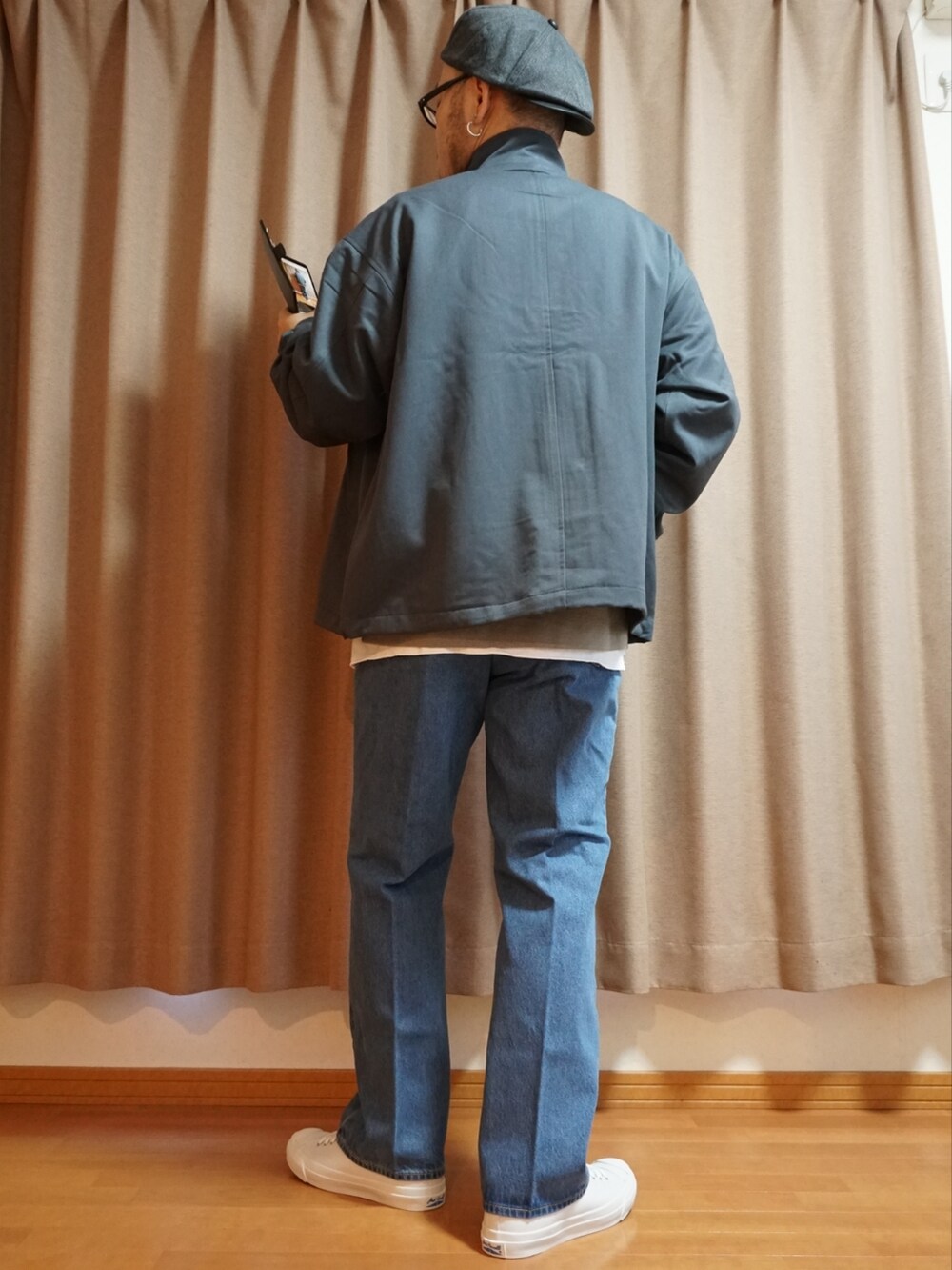 ホワイト系のスニーカー、ブルー系のデニムパンツ、グレー系のニット/セーターを着用したメンズの夏コーディネートの3枚目の写真