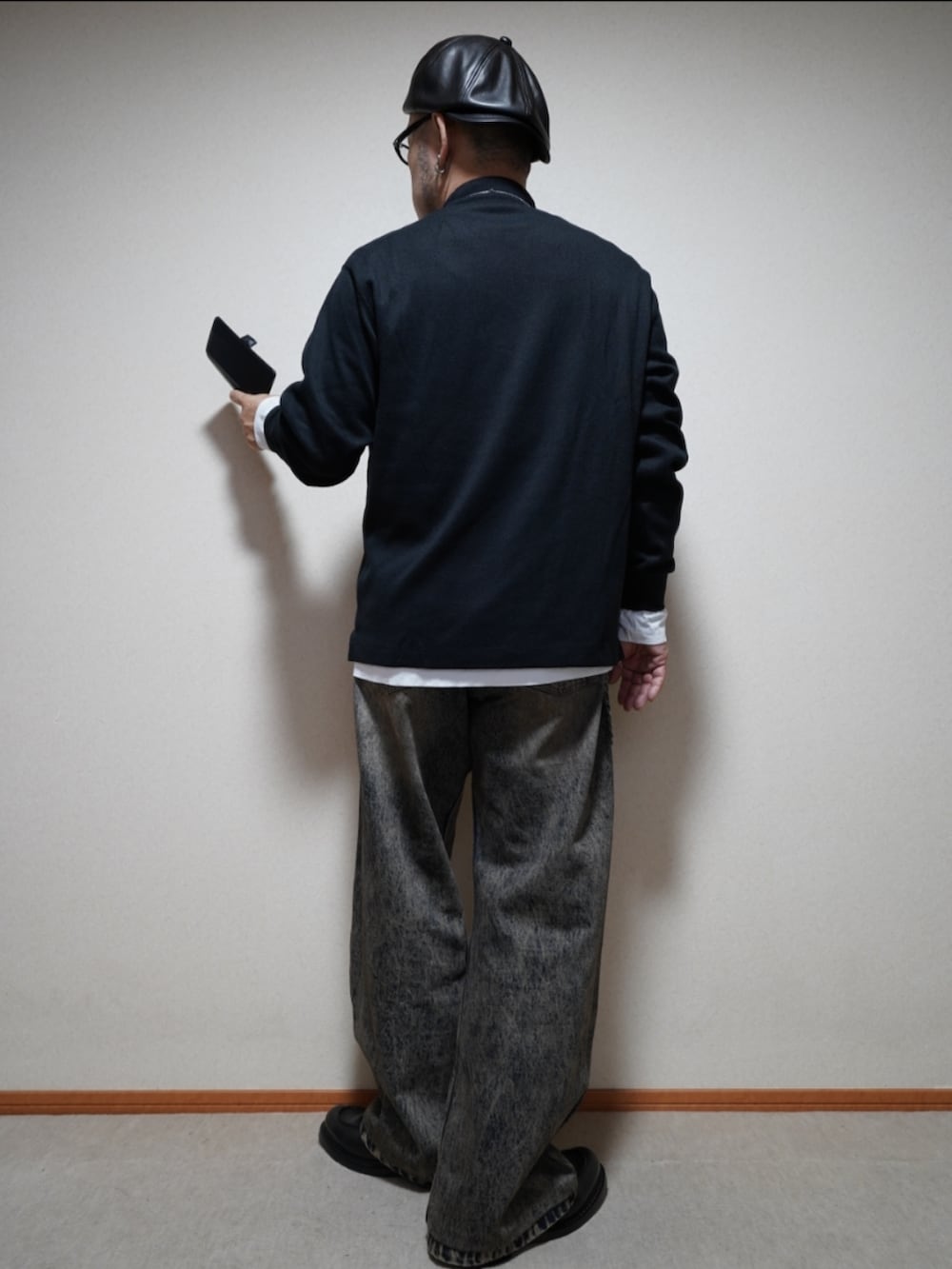 ブラック系のシューズ、ブルー系のデニムパンツ、ブラック系のトップスを着用したメンズの春コーディネートの3枚目の写真