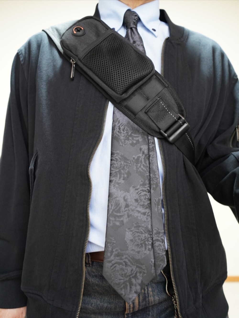 ブラック系のシューズ、ブルー系のデニムパンツ、ブラック系のMA-1を着用したメンズの春コーディネートの4枚目の写真