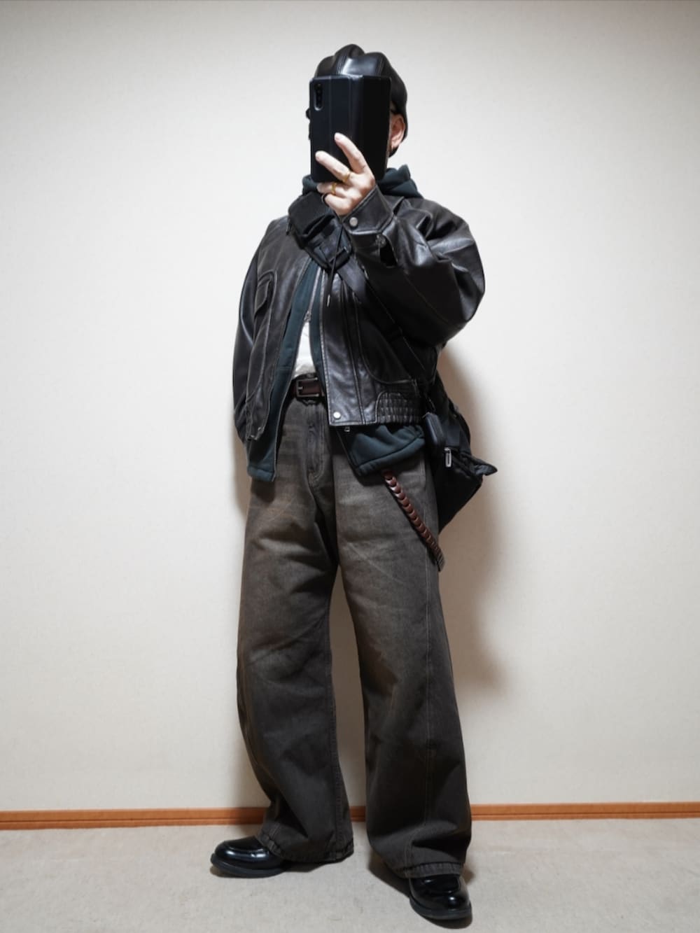 ブラック系のシューズ、ブラック系のデニムパンツ、ブラック系のパーカーを着用したメンズの春コーディネートの2枚目の写真